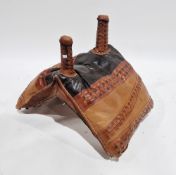 Middle Eastern multi-coloured leather camel saddle with two holding poles, 55cm high x 79cm wide x