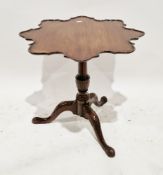 George III mahogany tilt-top table, the shaped top with raised moulded edge, on a carved turned