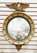 Giltwood-effect wall mirror in the Regency manner, the circular convex mirror surmounted by an eagle