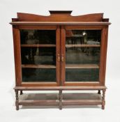 Late 19th/early 20th century Art Nouveau mahogany glazed dwarf library bookcase having a shaped back