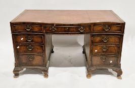 Walnut twin pedestal desk of serpentine outline, in the George III manner, the shaped top with brown