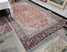 Eastern red ground carpet with central floral medallion on floral field, floral spandrels and