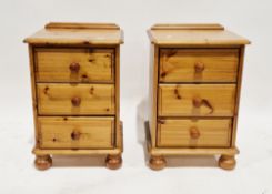 Pair of modern pine bedside chests of drawers, each with three drawers and pine knob handles, on