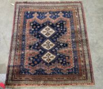 Large Eastern midnight blue ground rug with three central hooked lozenges on floral and geometric