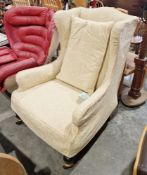 Wingback armchair in the George III manner, with pale yellow loose covers, on front turned