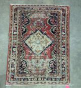 Eastern red ground rug with central hooked floral lozenge on floral pattern field, multiple