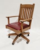 American Arts & Crafts-style oak office swivel elbow chair by The Stickley Brothers, having a slat