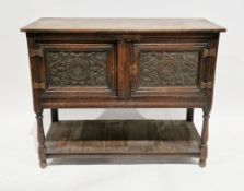 Oak dresser base in the 17th century manner, comprising two carved panel cupboard doors, on turned