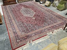 Large Eastern red ground carpet with central stepped lozenge on geometric pattern field, geometric