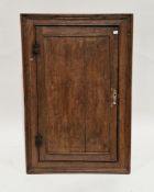 George III oak hanging corner cabinet, the single panel door opening to two fitted shelves (with
