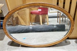 Early 20th century oak and ebony inlaid oval mirror with bevelled edge, 92cm x 63cm