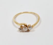 Yellow metal and diamond cross-over ring, comprising a row of three claw-set brilliant cut round