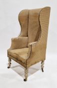 Georgian high wing-back fireside armchair with studded upholstery, on four tall turned baluster legs