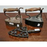 Two Victorian vintage irons with turned wooden handles and a pierced iron trivet (3)