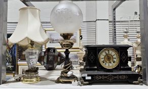 Early 20th century metal body mantel clock with ornamental mask to the sides and cast acanthus feet,