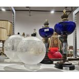 Pair of blue glass oil lamps with blue decorated ceramic columns and swag moulded decorated