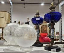 Pair of blue glass oil lamps with blue decorated ceramic columns and swag moulded decorated