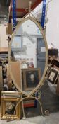 Contemporary oval-shaped white painted metal cheval mirror with leafy scroll supports and easel back
