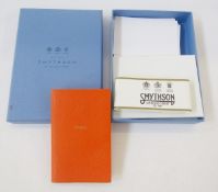 Smythson Smile orange notebook with various pieces of notepaper and envelopes, all within a Smythson