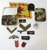 Collection of military cap badges, cloth badges, buttons and rank markings, together with a WWII