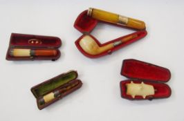 15ct and 9ct gold mounted amber cheroot holder, 11cm long (larger end damaged), and two white