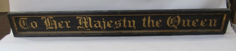 Antique 'To Her Majesty the Queen' gilt painted wooden wall-mounting sign of rectangular form, in