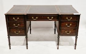 19th century mahogany kneehole desk of inverted breakfront form, the top with three purple tooled