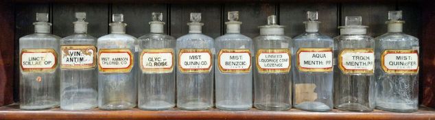 Ten large early 20th century 'label under glass' apothecary bottles and stoppers, each of