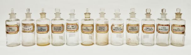 Twelve early 20th century 'label under glass' apothecary bottles and stoppers, each of cylindrical
