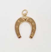 9ct yellow golf pendant in the form of a horseshoe, 1.5cm long, approximate weight 0.6 grams