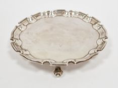 George V silver card tray, Chester 1931 having raised Chippendale border and on three scroll tab