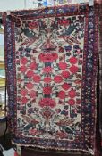 Small Persian rug, 20th century, woven with vases of pink flowers, parrots and blue and pink foliate