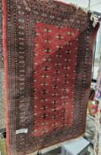 20th century Caucasian red ground wool rug, the centre with interlocking lozenge shaped panels