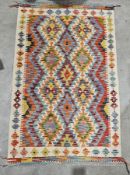 Chobi kilim rug, 20th century, woven with interlocking radiating lozenges in a bold palette within a