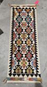 Chobi kilim runner, 20th century, woven in black, cream and bold palette with repeating foliate