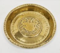 Nuremberg brass armorial alms dish, mid-16th century, the centre decorated in repousse with the arms