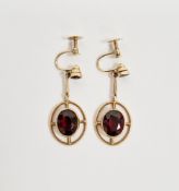 Pair of 9ct yellow gold and garnet drop earrings, each with an oval open design set with an oval and