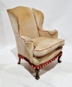 Wingback armchair in the George III manner, with cream upholstery with a pink and red pipe edge,