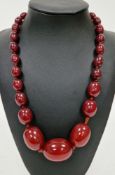 Cherry bakelite amber bead necklace, comprising twenty seven strung graduated oval beads, largest