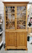 Modern pine library bookcase in the George III manner, the twin astragal glazed doors opening to