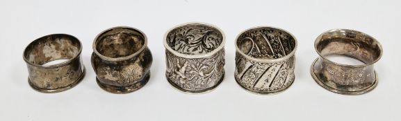 Five late 19th/early 20th century silver napkin rings, including: an example cast in relief with