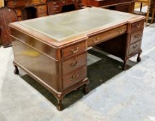 Mahogany twin pedestal inverted breakfront desk in the George III manner, with a green tooled