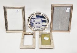 Collection of four silver-framed easel back photograph frames including a plain rectangular frame