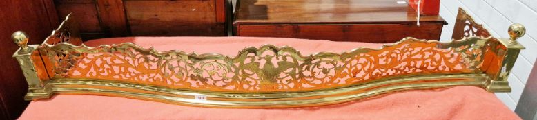 George III brass fender of serpentine outline, having pierced decoration of a central phoenix