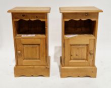 Pair of modern pine bedside cabinets, having a shaped frieze over a shelf with cupboard below, on