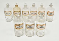 Nine large early 20th century 'label under glass' apothecary bottles and stoppers, each of