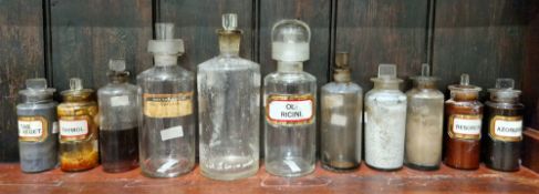 A group of early 20th century glass apothecary bottles and stoppers, each of cylindrical form with
