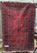 20th century Persian red ground carpet, woven in dark blue with star-shaped medallions and flowering