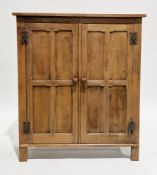Arts & Crafts oak cupboard in the Cotswold School manner, comprising two panel doors with metal H-