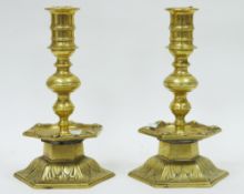 Pair of heavy brass candlesticks with turned ringed stems, hexagonal drip trays, the edges casts